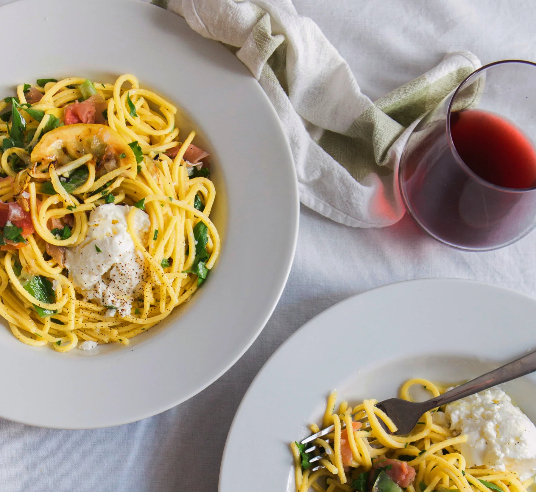 Pasta och vin på ett dukat bord